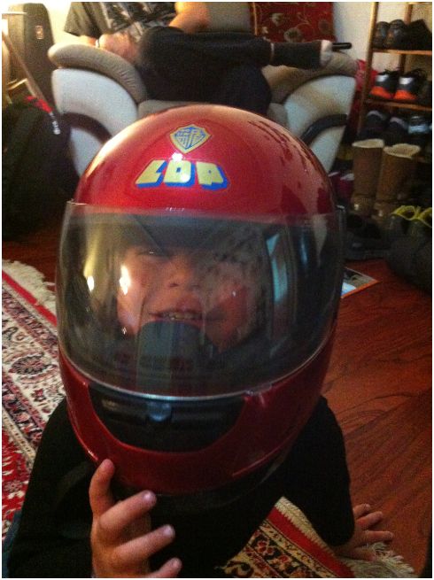 My little buddy Raden at our house wearing one of our motorcycle helmets.